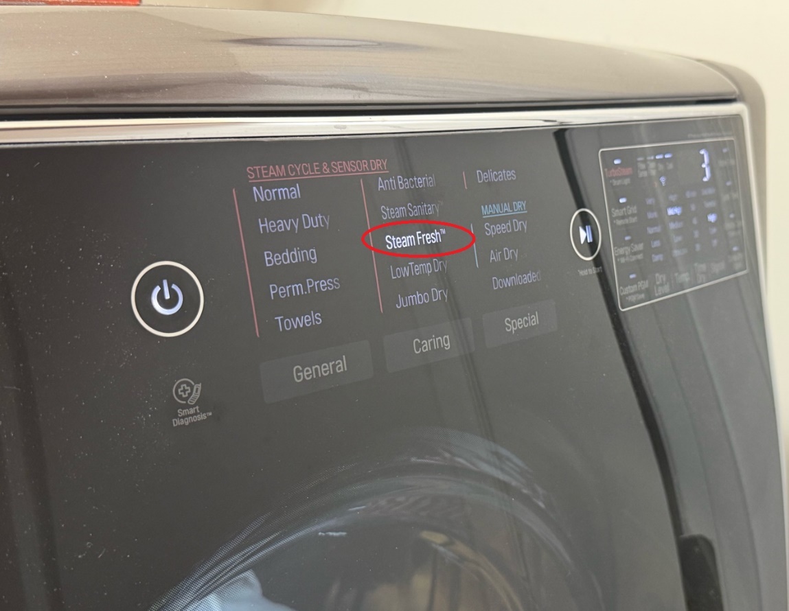 Close-up of the LG SIGNATURE dryer showing the TurboSteam feature interface, demonstrating the wrinkle-reduction and fabric-refresh capability for seniors.