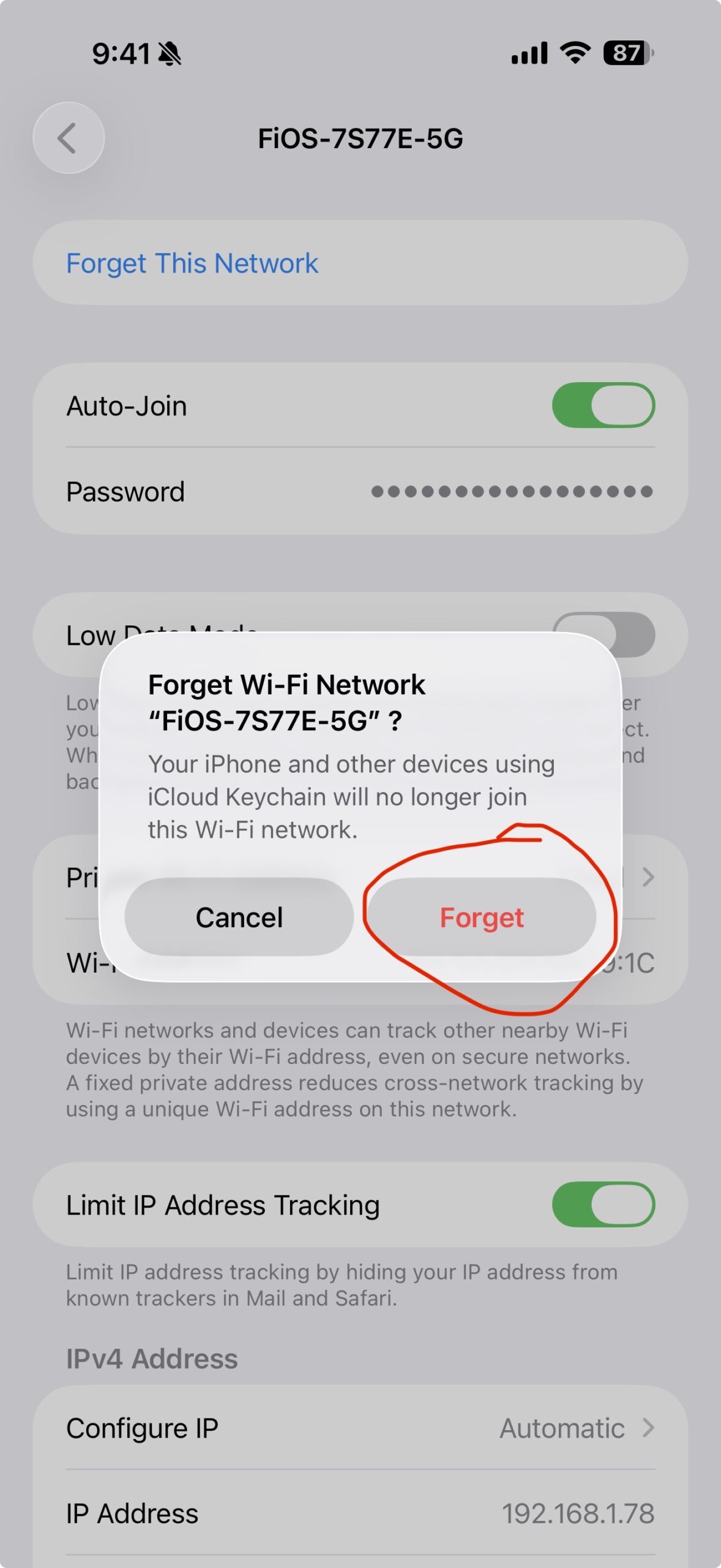 Screenshot of an iPhone confirmation popup. The popup reads "Forget Wi-Fi Network FiOS-7S77E-5G?" with explanatory text saying that iPhone and other devices using iCloud Keychain will no longer join this Wi-Fi network. Two buttons appear: a black "Cancel" button on the left and a red "Forget" button on the right. The red Forget button is circled in red.